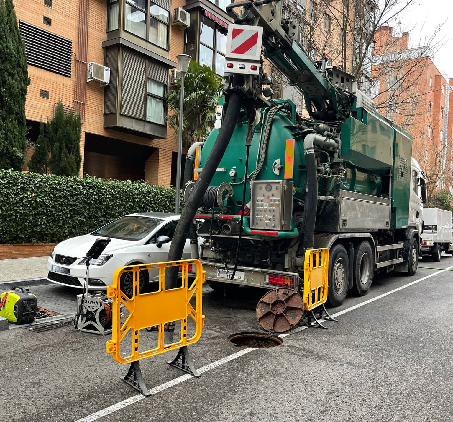 Camión de limpieza urbana trabajando en arqueta de saneamiento en Madrid